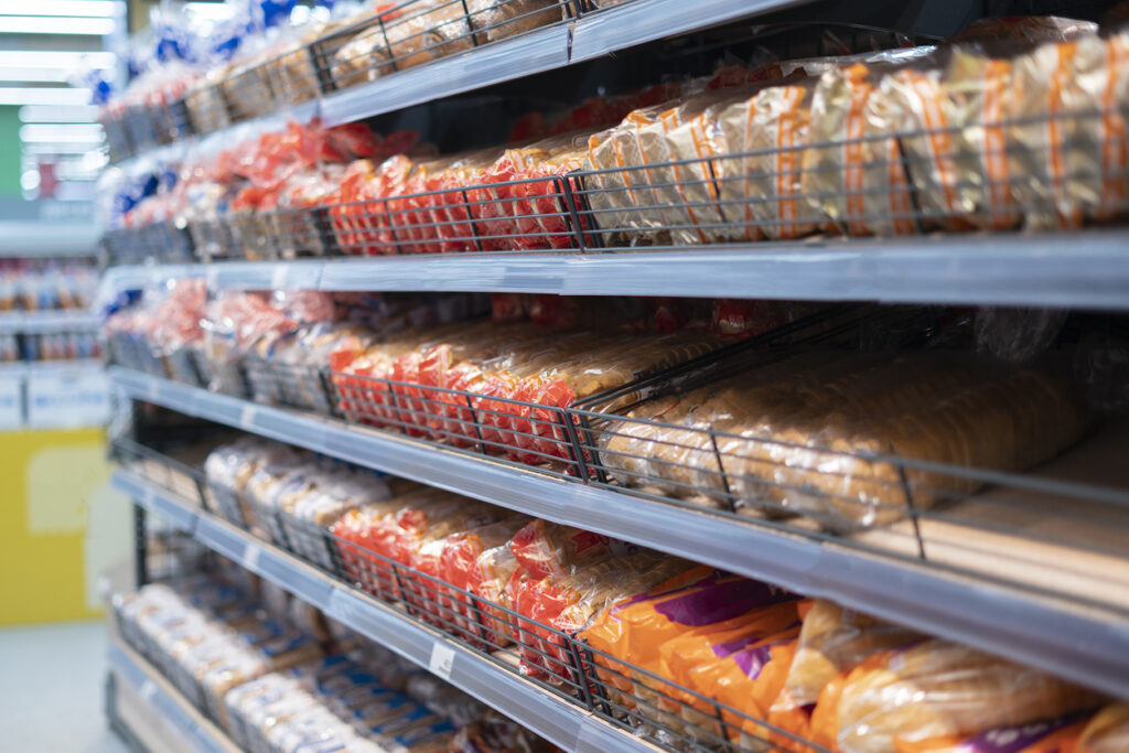 loaves of bagged bread on supermarket shelf